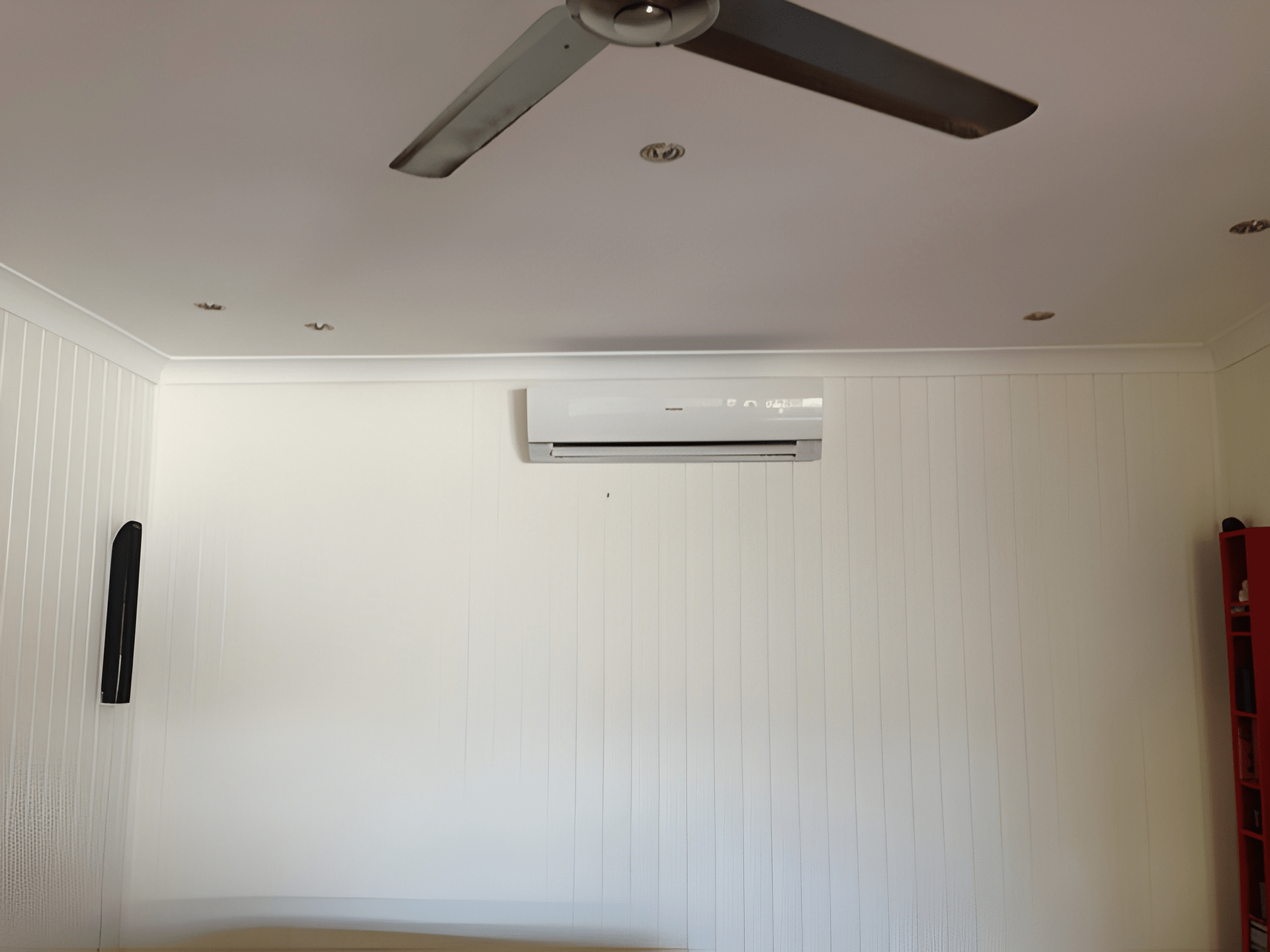 White Paneled Wall with Air Conditioner and Ceiling Fan — Allchin Airconditioning & Refrigeration Electrical in Caloundra, QLD