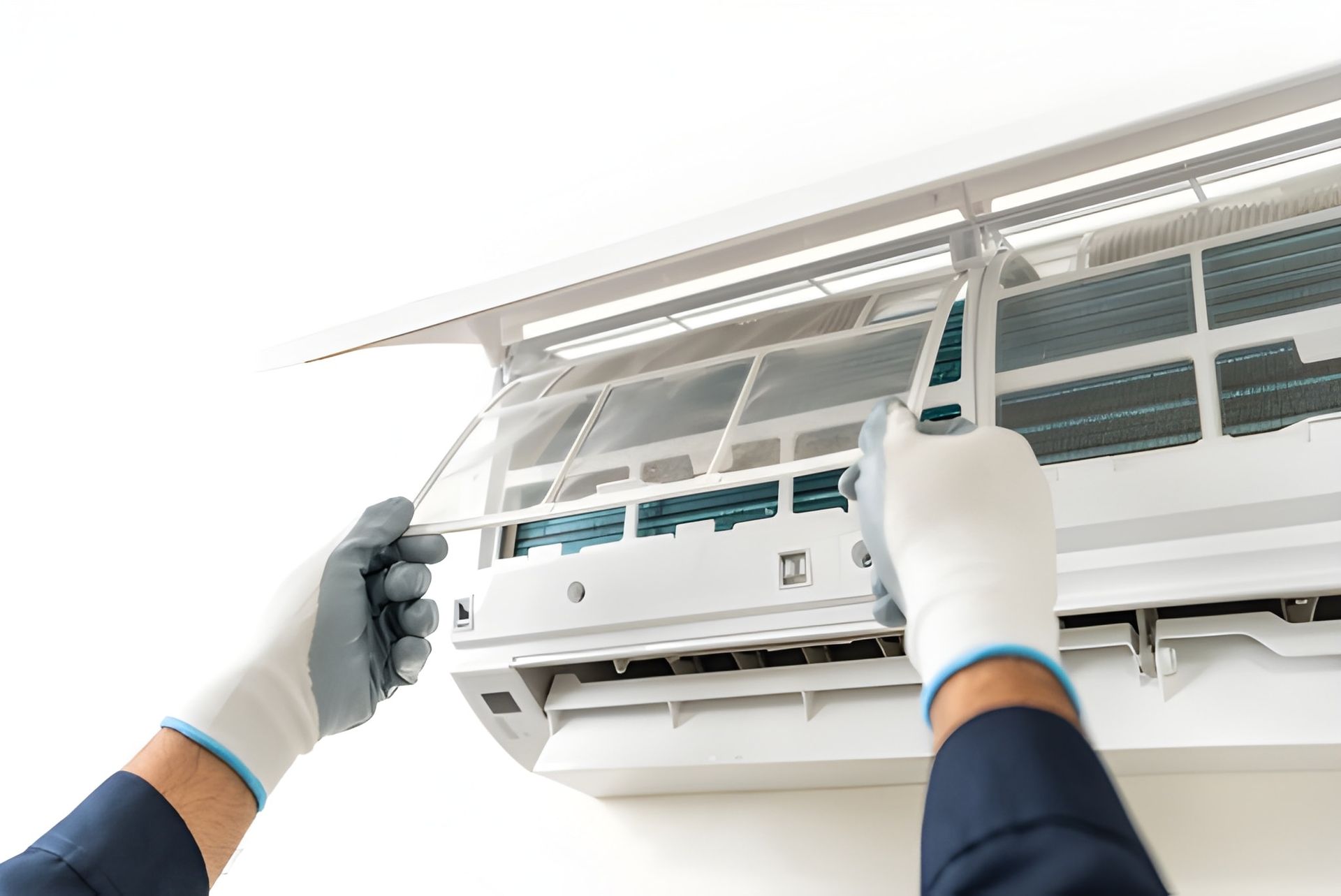 A Person Is Cleaning the Filter of A White Air Conditioning Unit — Allchin Airconditioning & Refrigeration Electrical in Caloundra, QLD