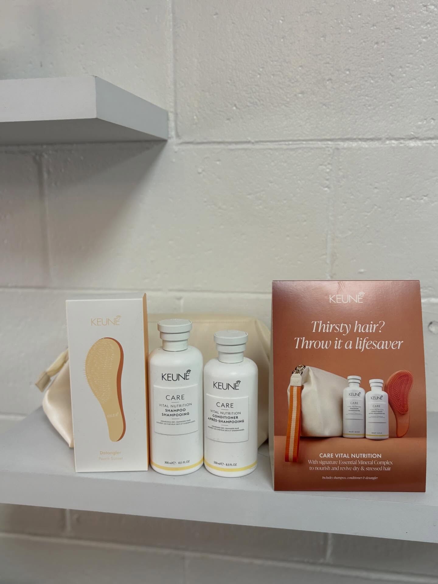 Skincare products and a brochure arranged on a shelf against a white tiled wall