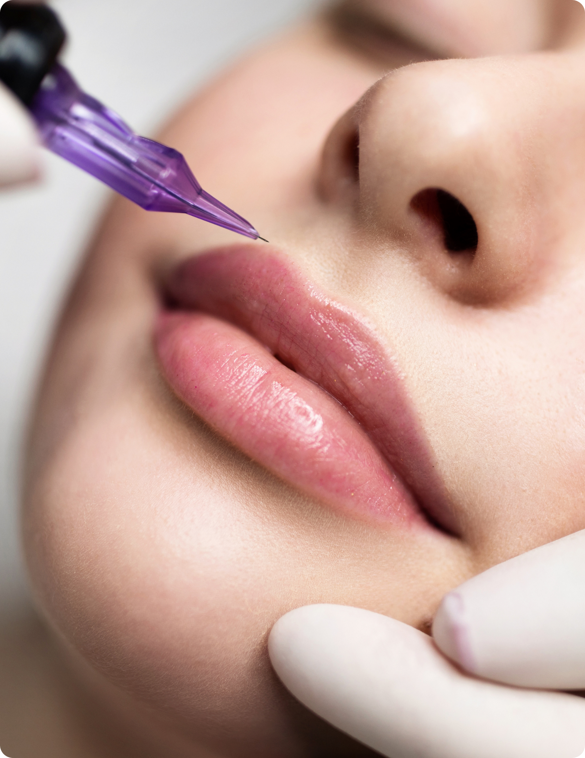 Eine Frau lässt sich mit einer violetten Nadel ein Lippentätowieren.