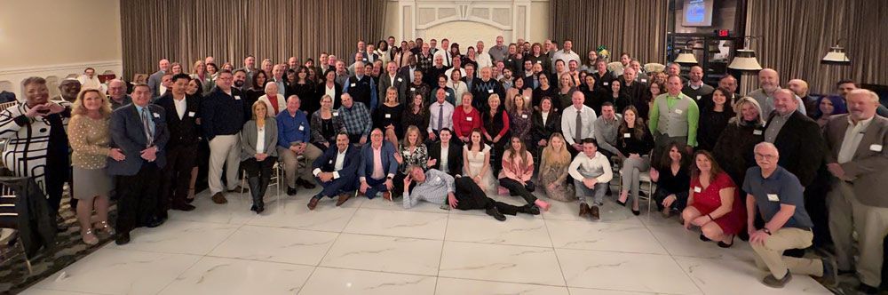 A large group of people are posing for a picture in a room.