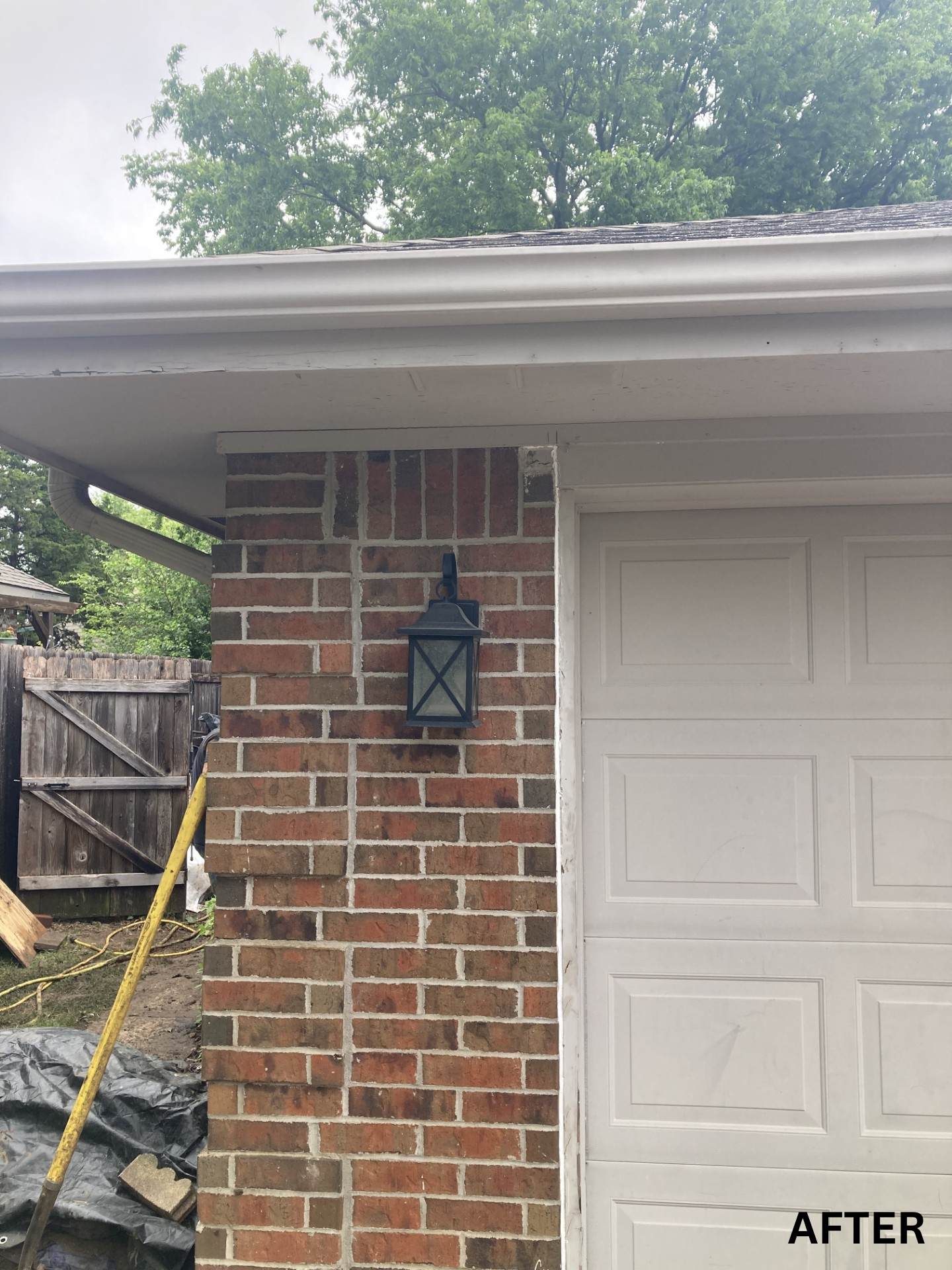 Brick house corner with black lantern beside a white garage door, labeled “AFTER.”