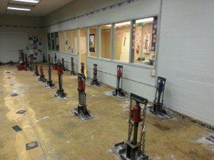 A room with many vertical hydraulic jacks installed on the floor, likely for structural leveling or repair work.