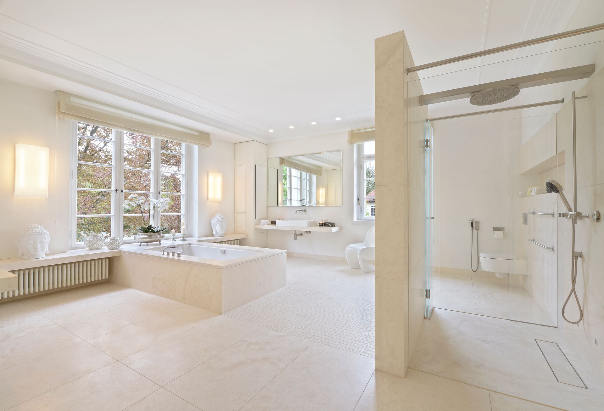 Bright white luxury bathroom with soaking tub, large windows, and glass walk-in shower