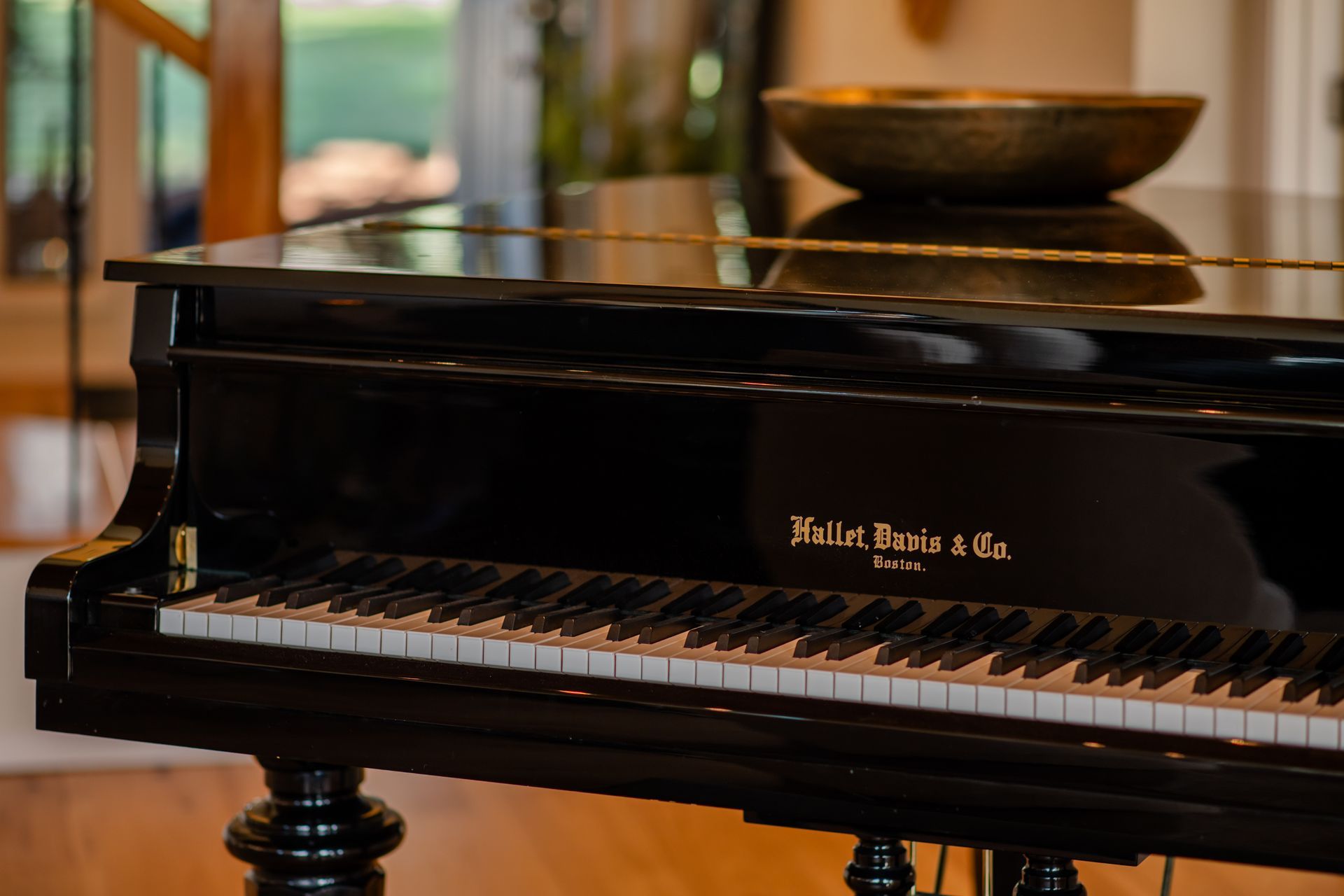 Black grand piano with closed lid in a warmly lit room