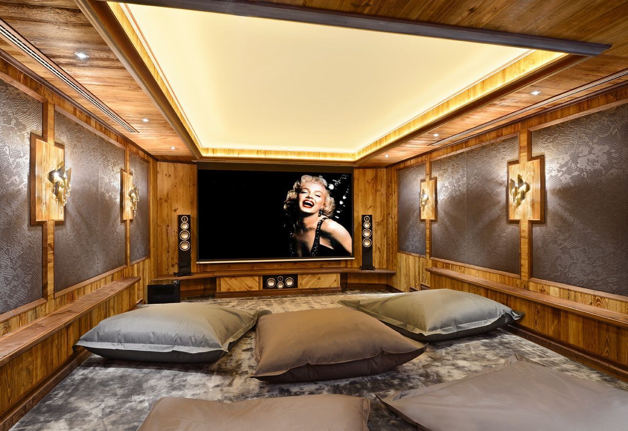 Luxurious wood-paneled bedroom with a large bed, ambient ceiling lights, and a wall-mounted portrait.