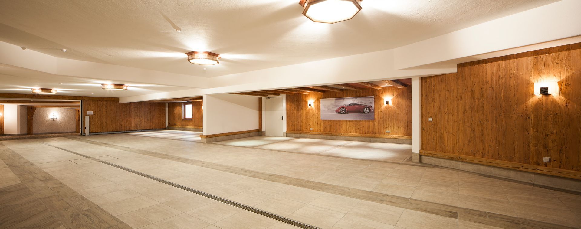 Empty wood-paneled banquet hall with carpeted floor and ceiling lights