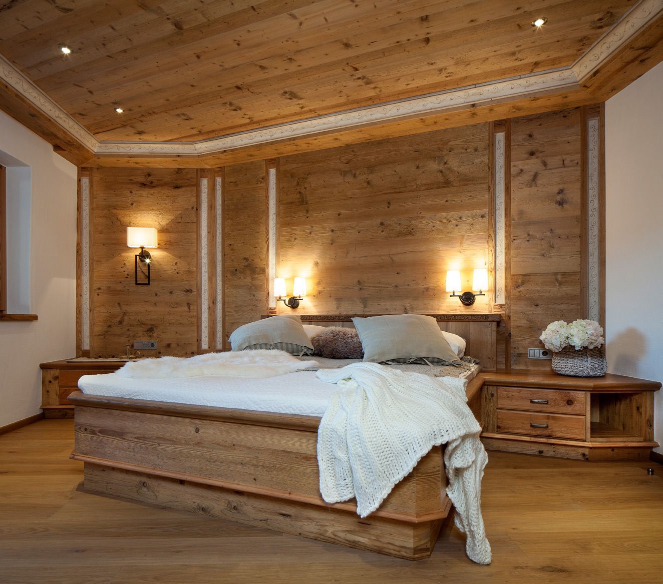 Warm rustic bedroom with a wooden bed, soft lighting, and natural wood-paneled walls