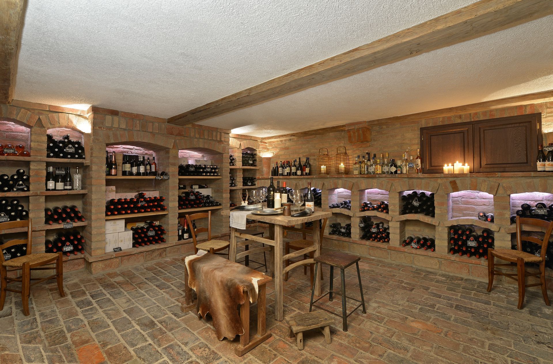 Wine cellar with wooden racks, tasting table, and warm ambient lighting