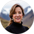 Woman smiling in a black turtleneck against a blurred mountain background