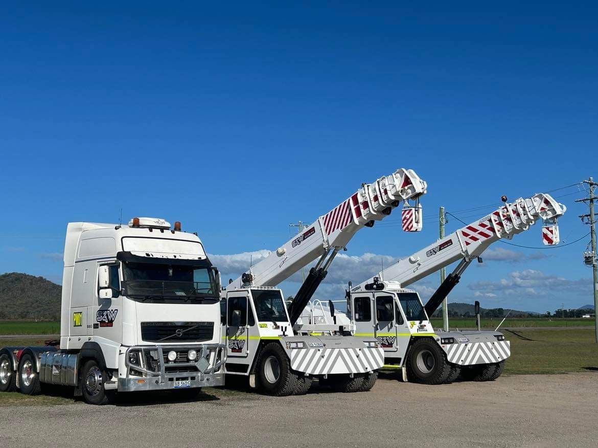 Three White Crane Trucks Next To Eachother— S & W Crane Hire In Bowen, QLD