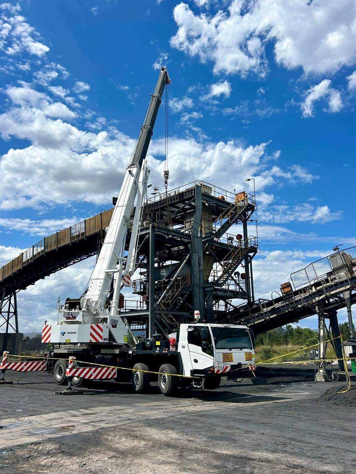A Large Crane Is Parked On The Side Of The Road At Sunset — S & W Crane Hire In Bowen, QLD