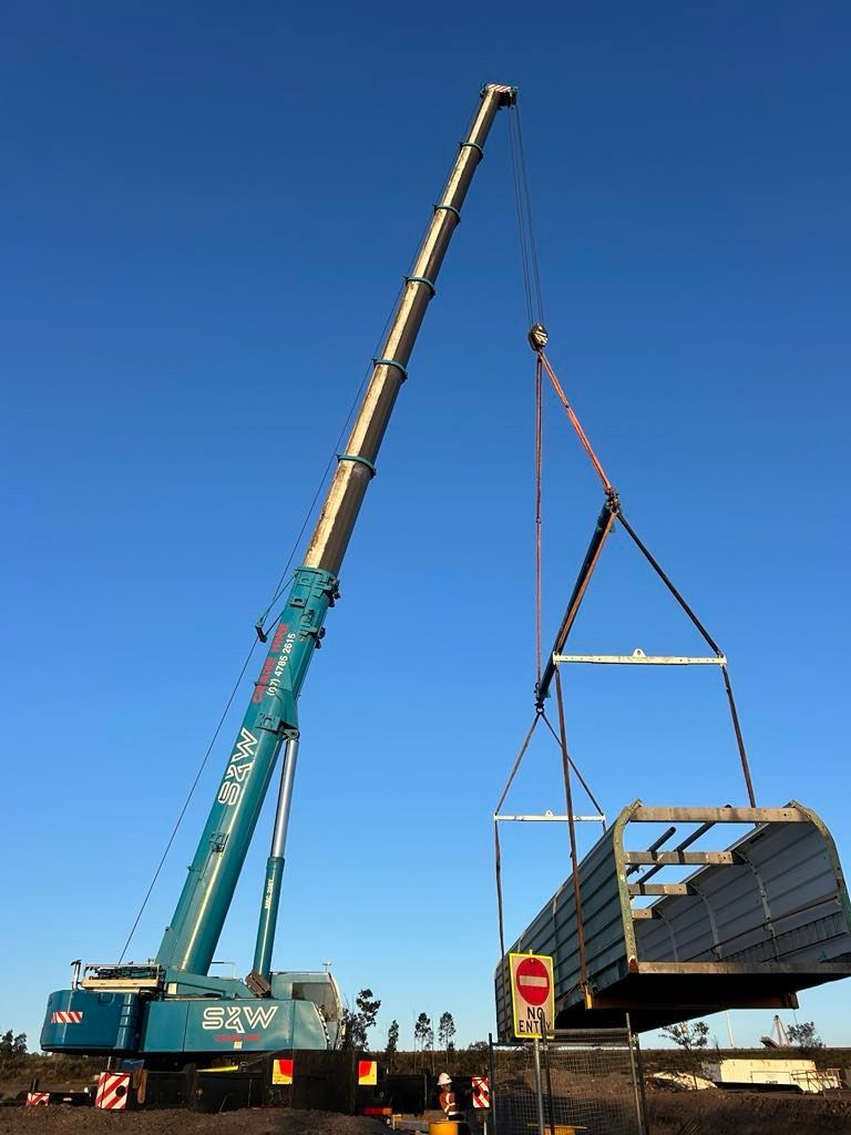 A large blue crane is lifting a large piece of metal — S & W Crane Hire In Bowen, QLD