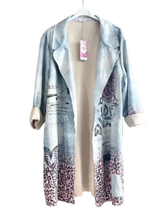 Mujer caminando por una calle empedrada con una blusa blanca, jeans y un abrigo estampado estilo kimono.