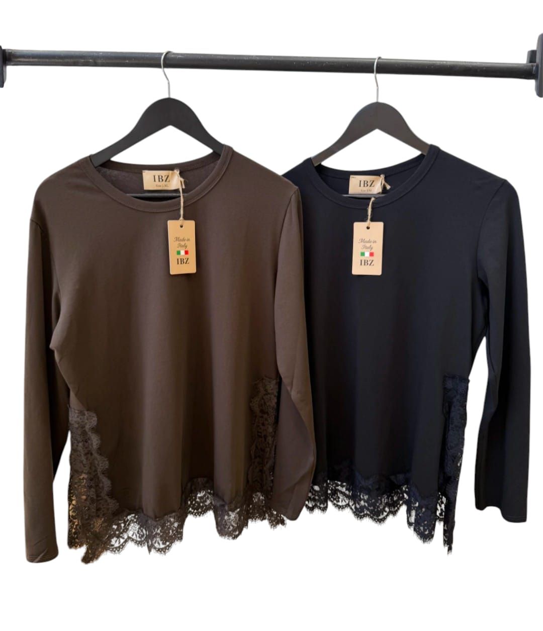 Dos blusas de manga larga con ribete de encaje, una marrón y otra azul marino, colgadas en perchas negras.