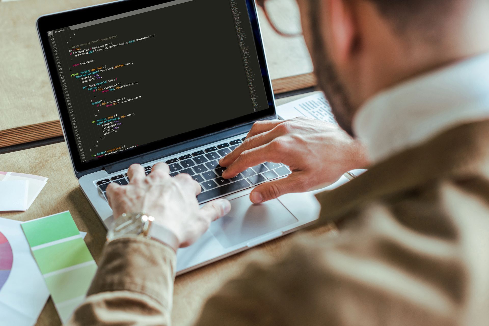 A man coding on laptop.
