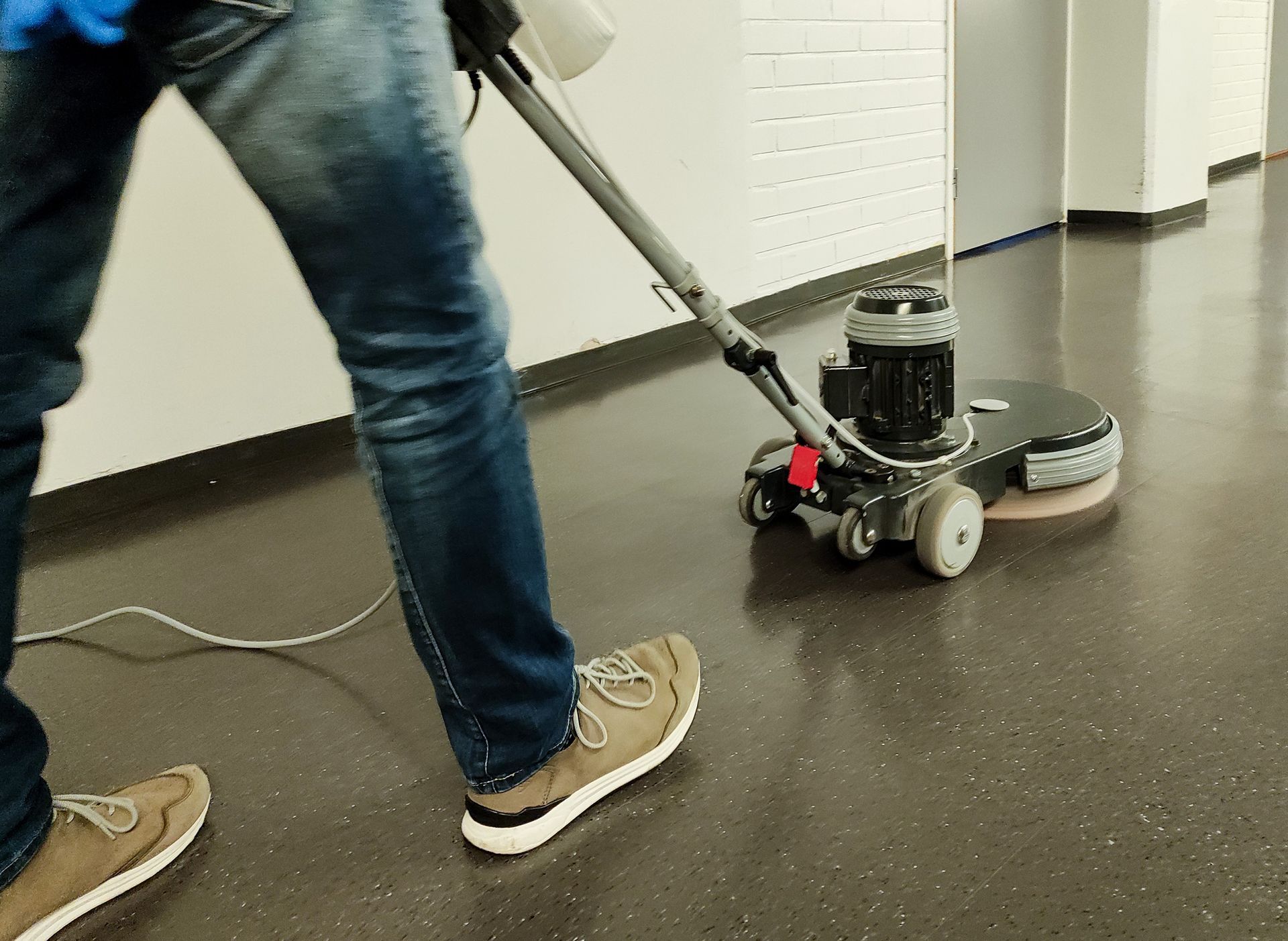 A person is cleaning a carpet with a vacuum cleaner in a living room.
