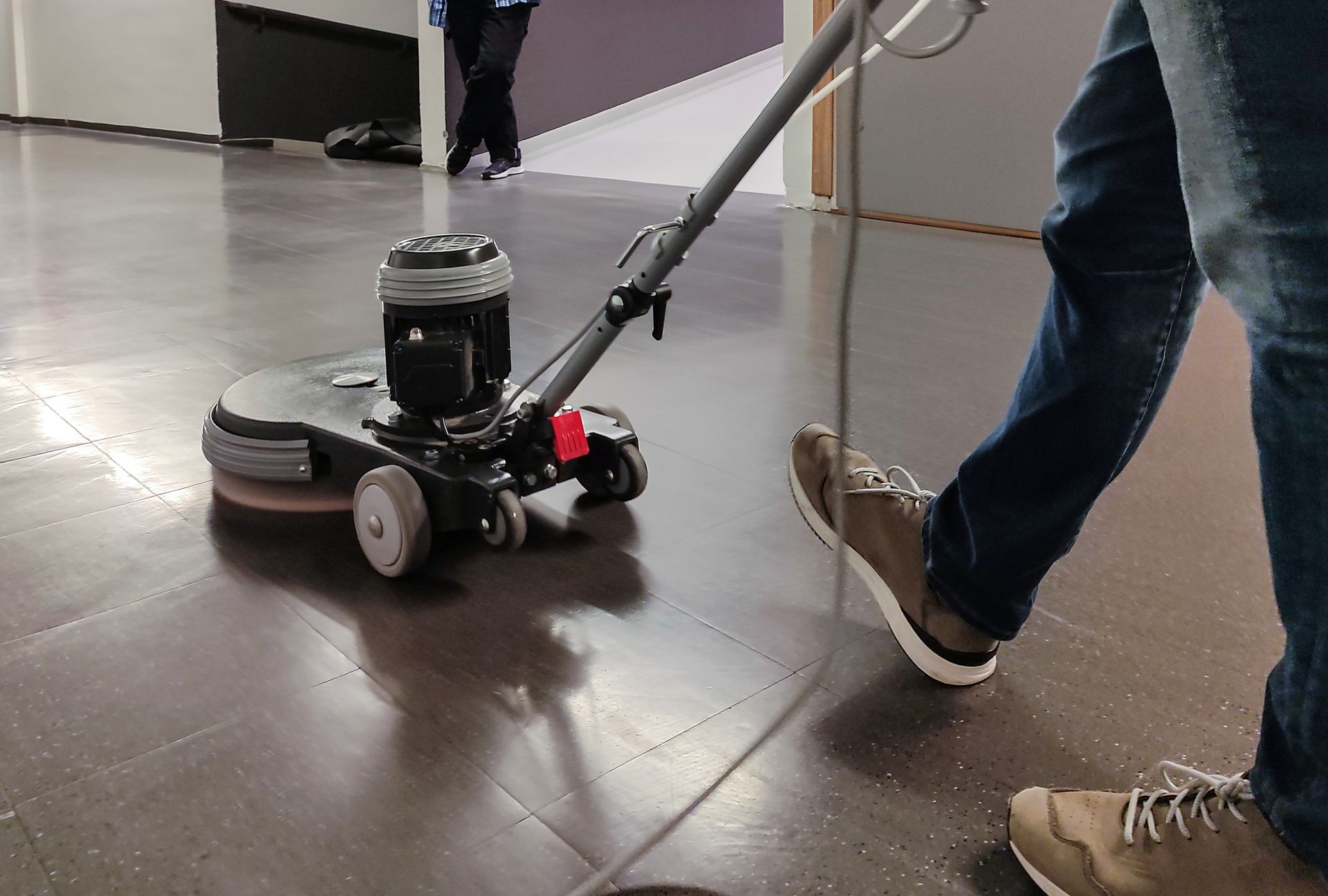 A person is cleaning a carpet with a vacuum cleaner in a living room.