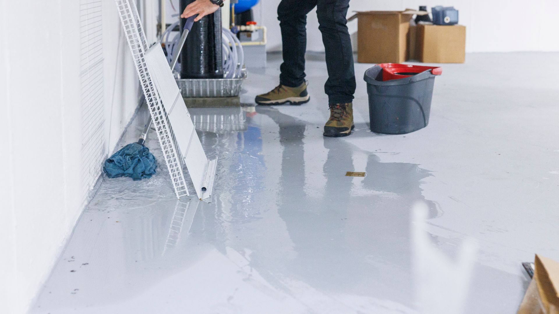 A man is cleaning the floor with a mop and bucket.