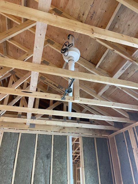 Wooden roof framework with a ventilation system installed. Insulation is visible on the wall.