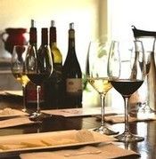 Wine glasses and bottles on a set dining table by a sunlit window