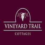 Vineyard Trail Cottages logo on a burgundy background with white text and a circular vine emblem