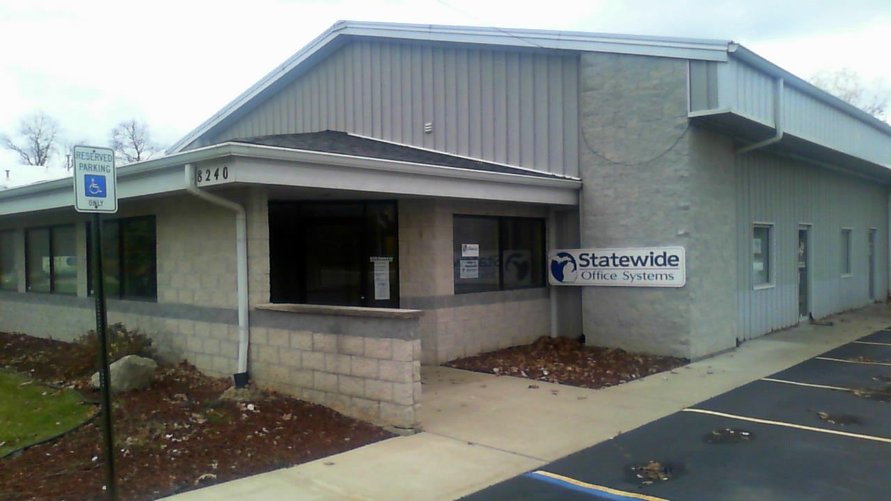 Exterior view of a commercial building; blue sign reads 