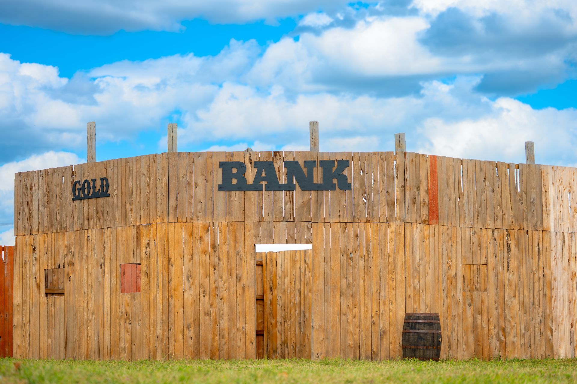Wooden bank building against a cloudy blue sky. The word 