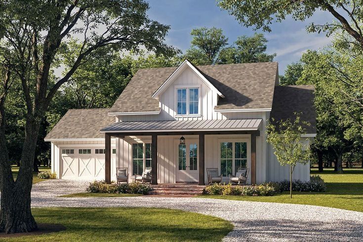 White farmhouse with a porch, driveway, and trees.