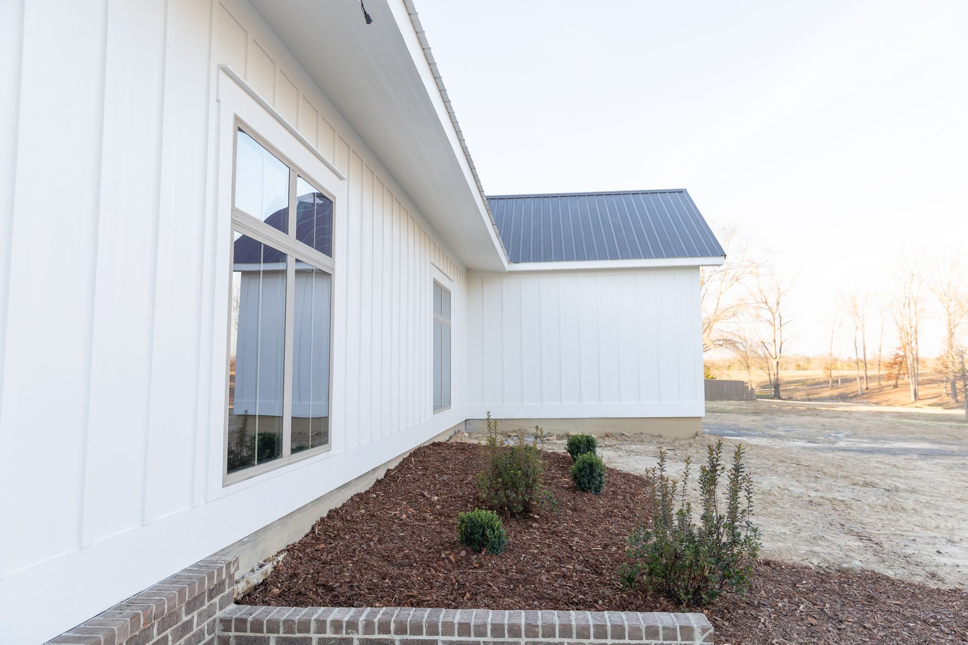 White house exterior with dark roof and landscaping.