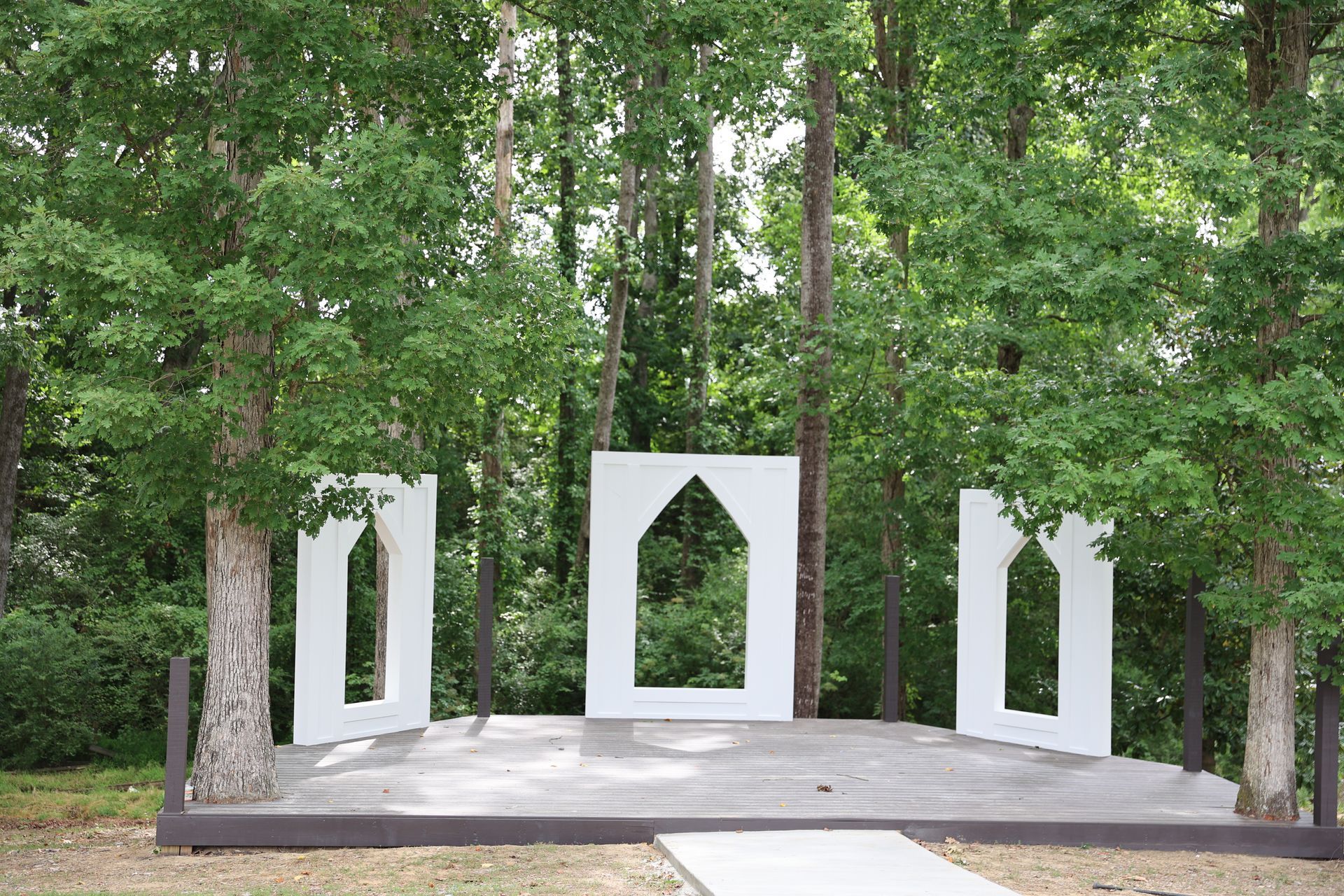 A sculpture in the middle of a forest with trees in the background.