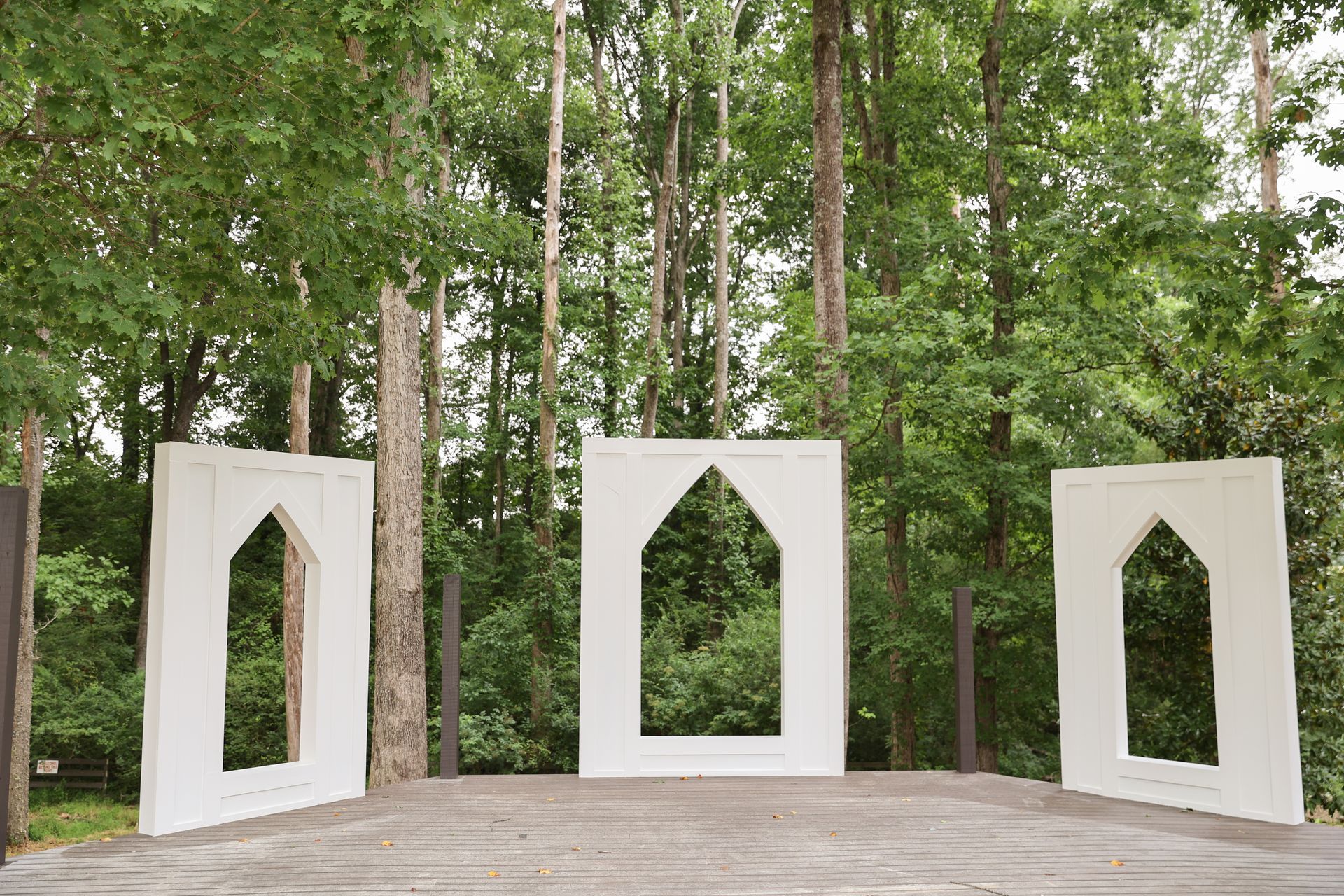 A row of white squares with holes in them in the middle of a forest