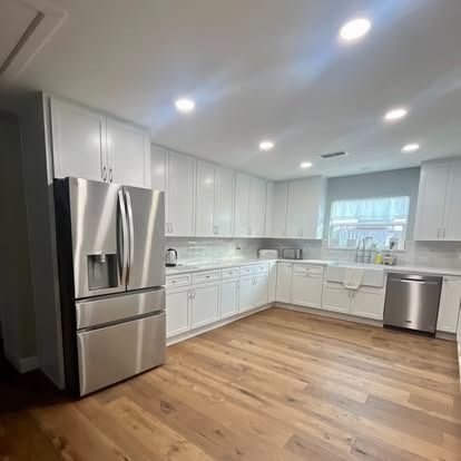 Black accent wall with diagonal trim, two tall windows, and a wood floor in an empty room.