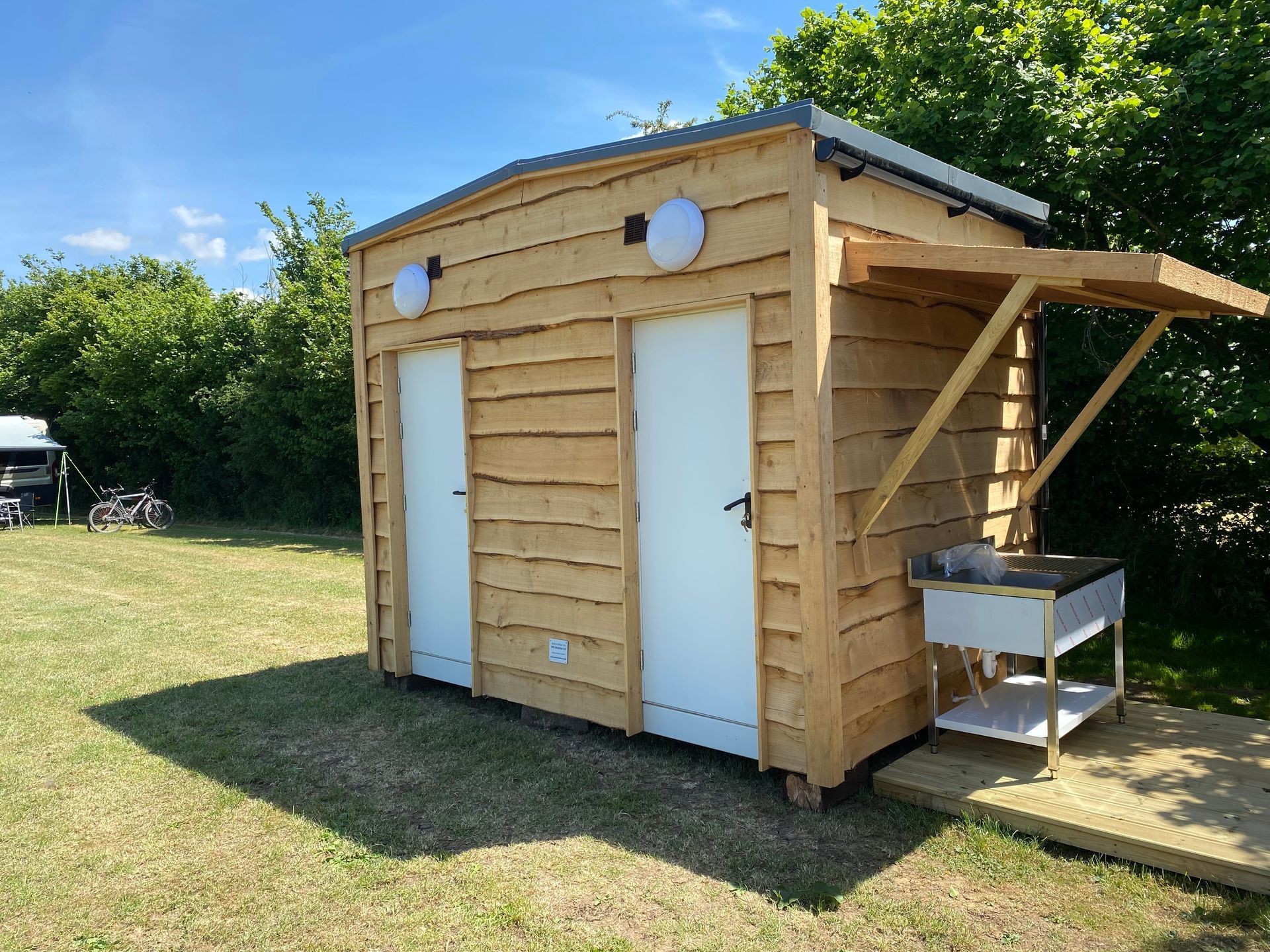 Shower and toilet with exterior sink for a campsite.