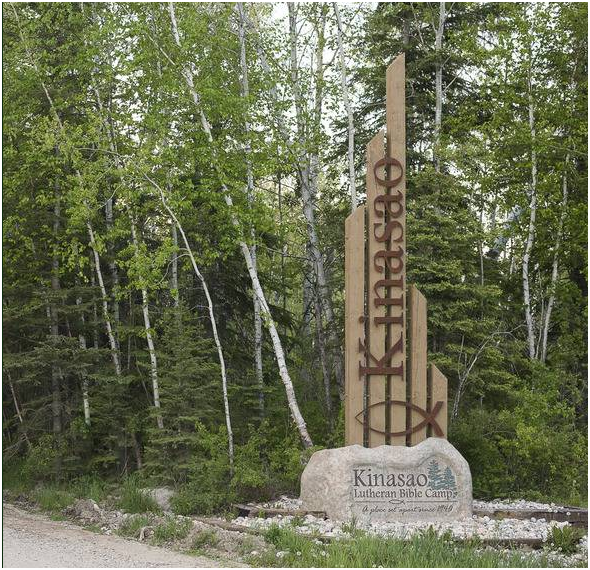 Kinosoo sign with tall wooden posts beside a gravel path in a birch forest