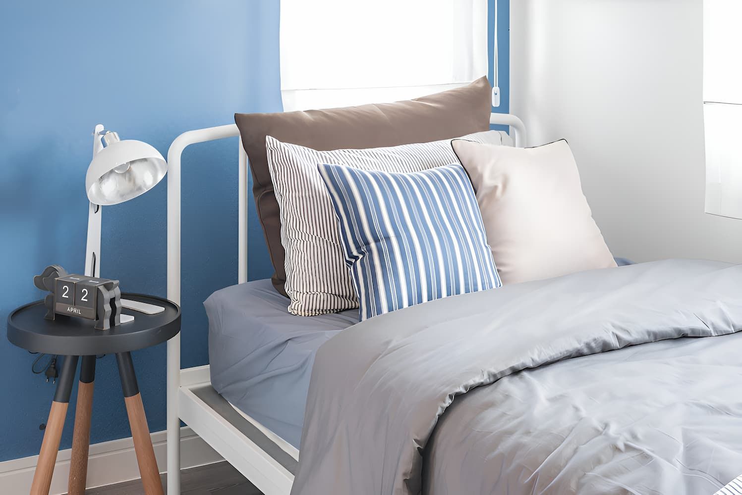 A Bedroom With a Bed, Nightstand, Lamp and Blue Walls — Bryants Beds and Mattresses In Lismore, NSW