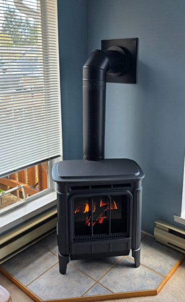 Black cast iron gas stove in a corner with angled flue