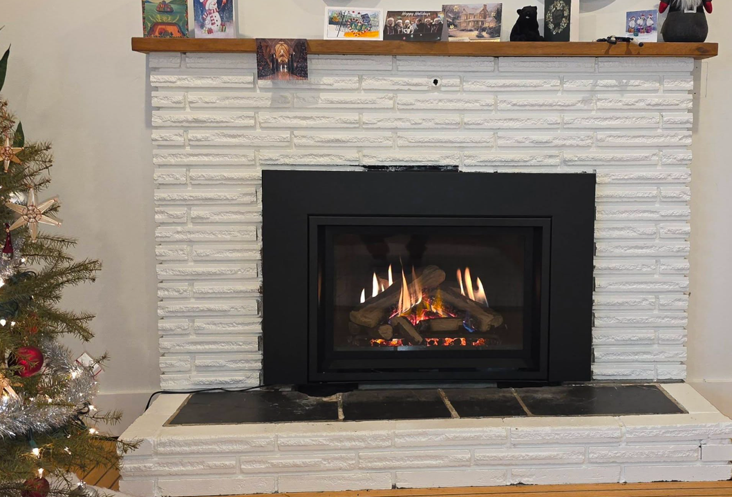 Gas fireplace insert with a Christmas tree beside it