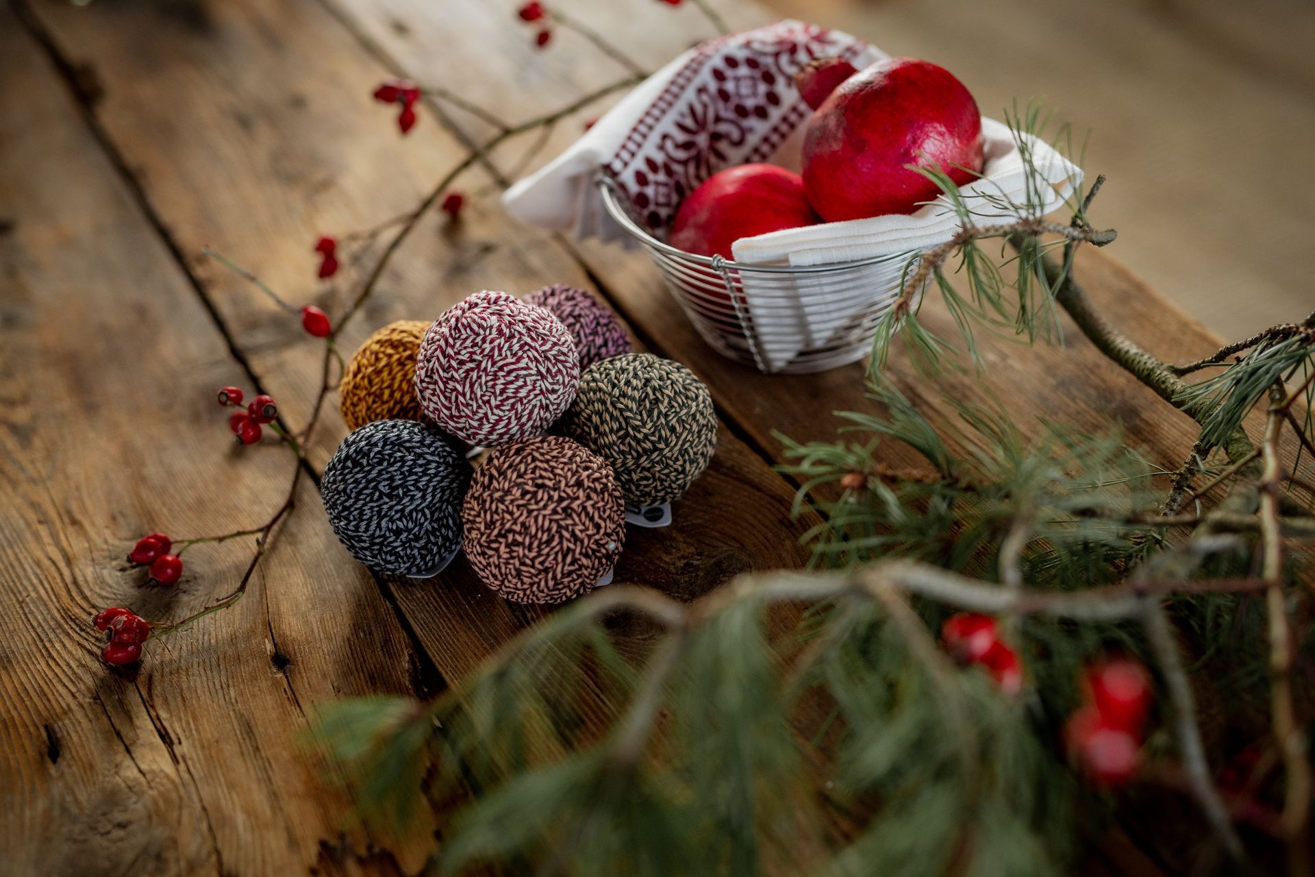 Wooden table with a basket of red eggs and colorful decorative balls.