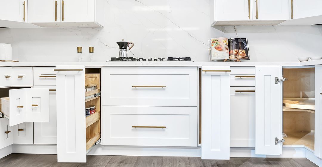 Modern white kitchen with open cabinets, island drawers, and built-in appliances