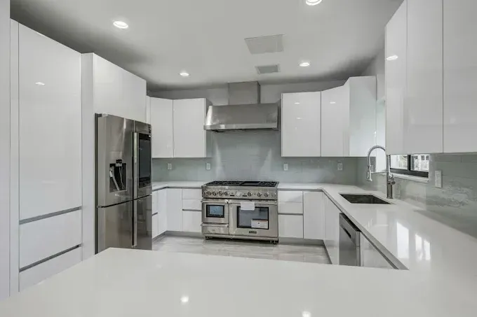 Bright modern white kitchen with stainless steel appliances and large island countertop