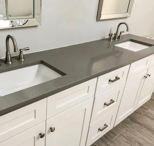 Modern bathroom vanity with double sinks, gray countertop, white cabinets, and chrome faucets.