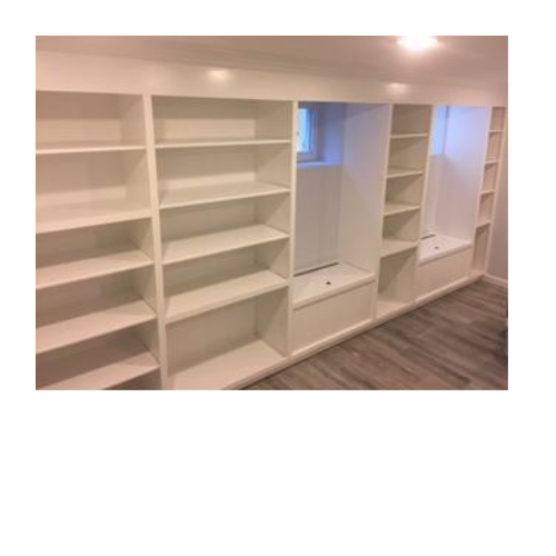 A room with a lot of shelves and a window.