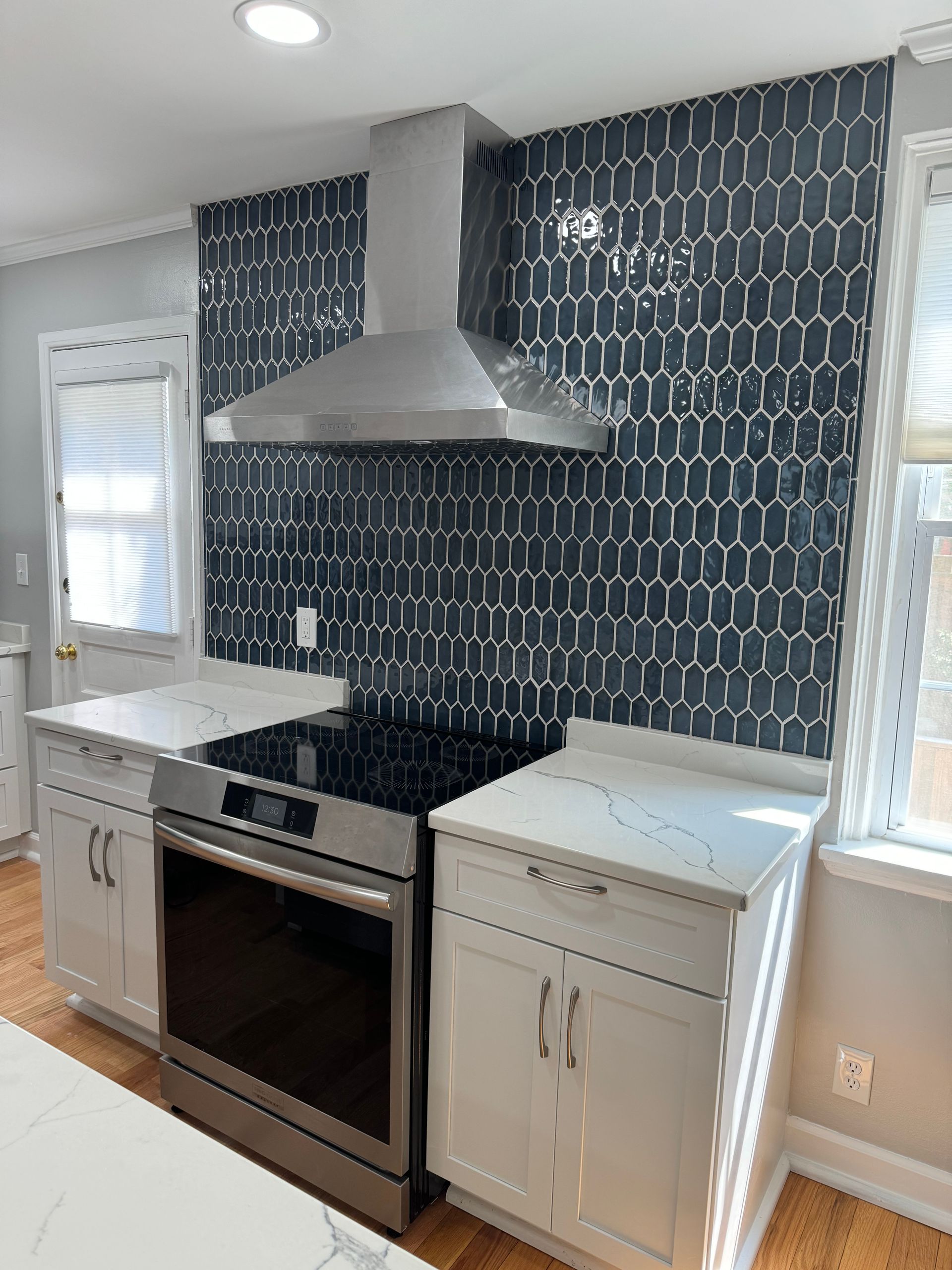 A kitchen with stainless steel appliances and white cabinets.