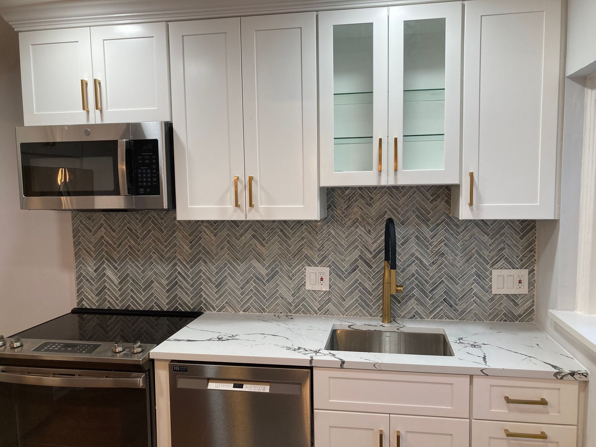 A kitchen with white cabinets and stainless steel appliances