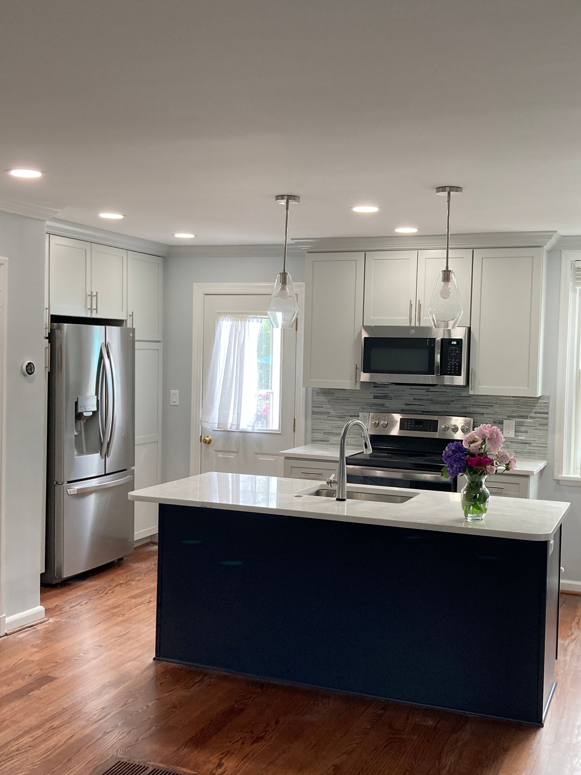A kitchen with stainless steel appliances and a blue island