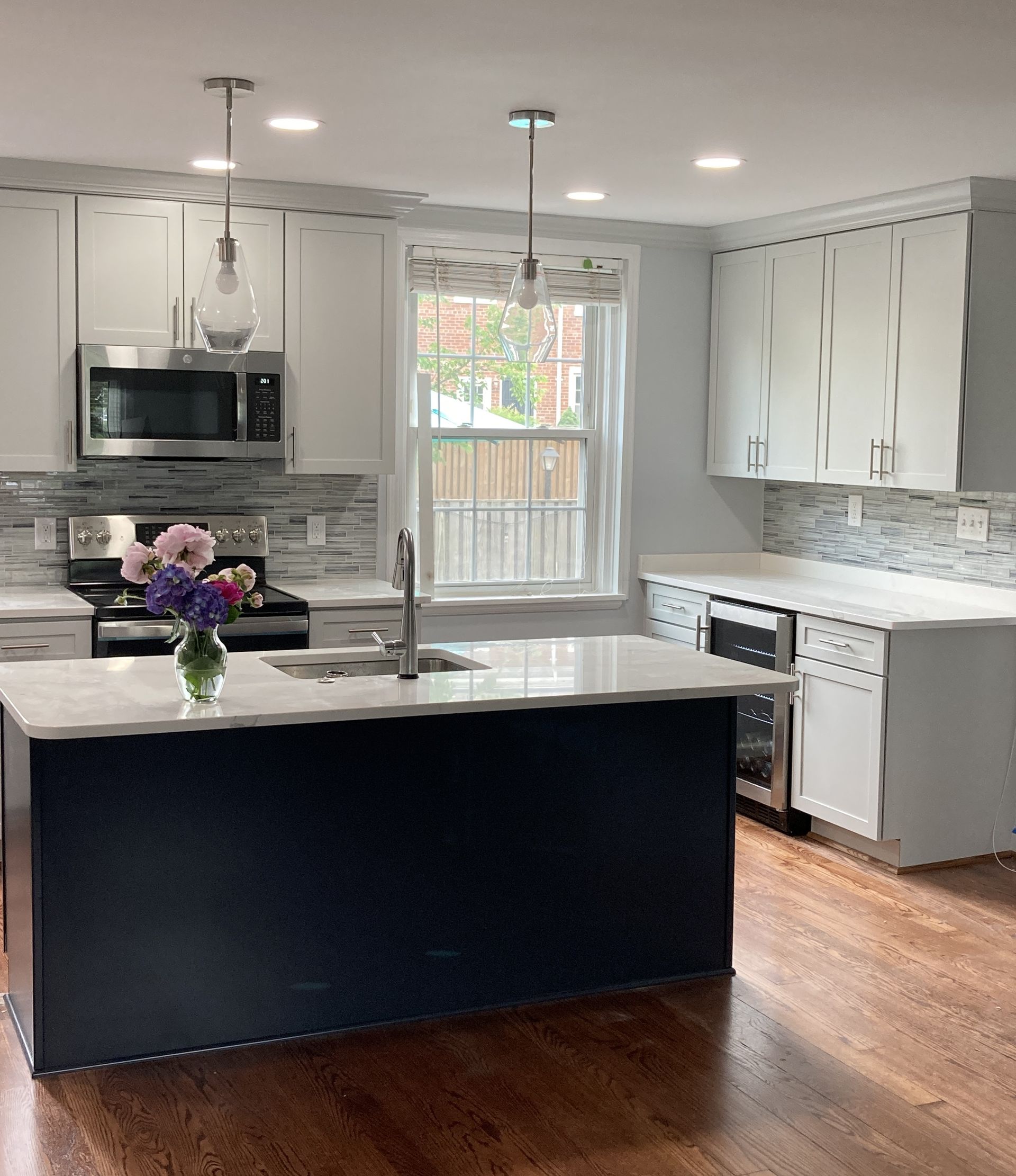 A kitchen with a large island and a vase of flowers on the counter
