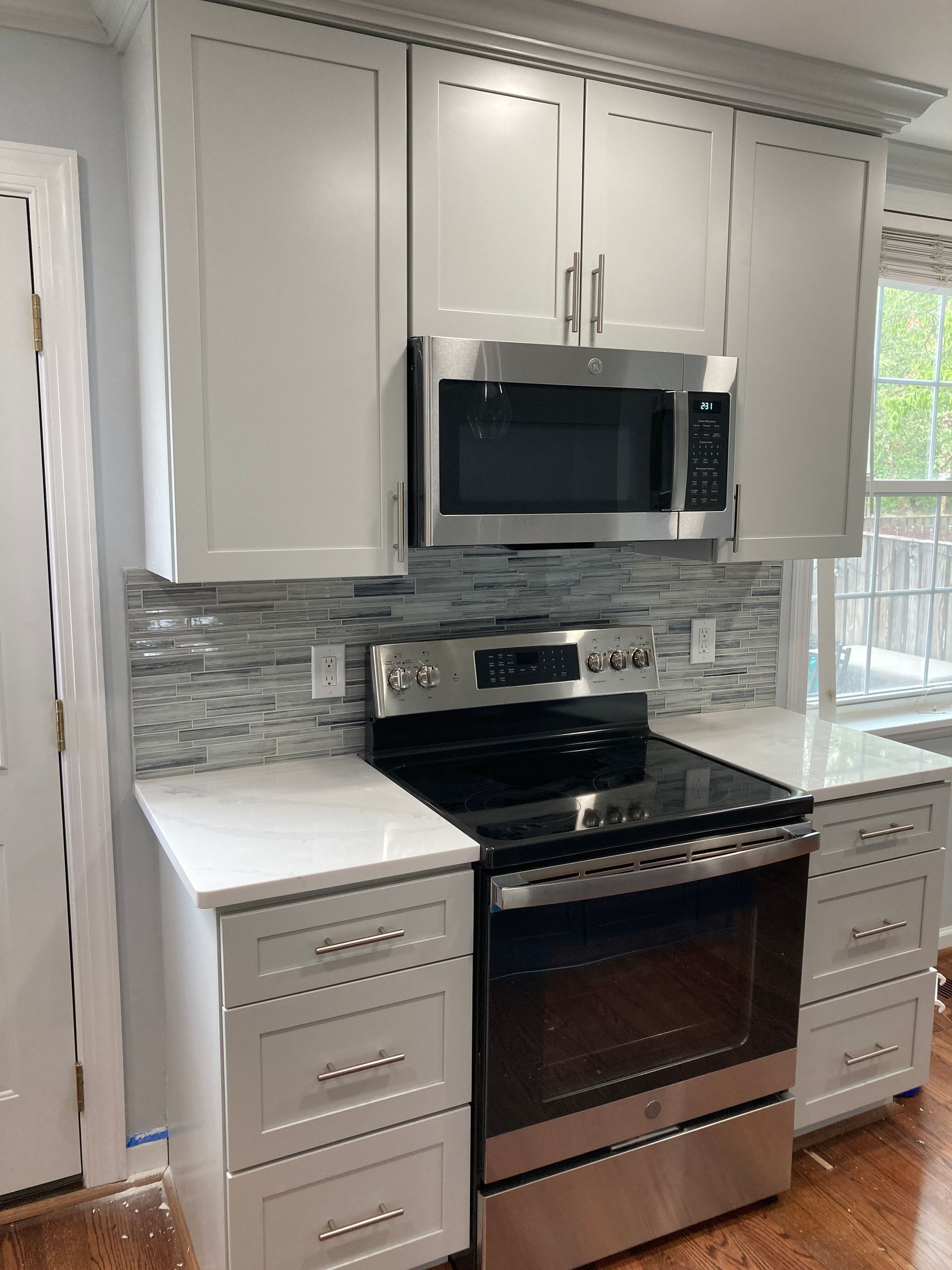 A kitchen with stainless steel appliances and white cabinets.