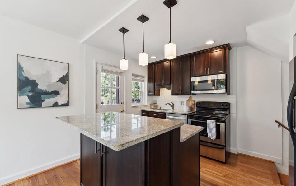 A kitchen with a large island and stainless steel appliances.