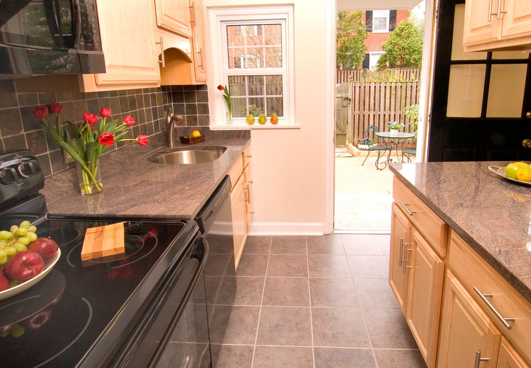 A kitchen with a black stove top oven and granite counter tops